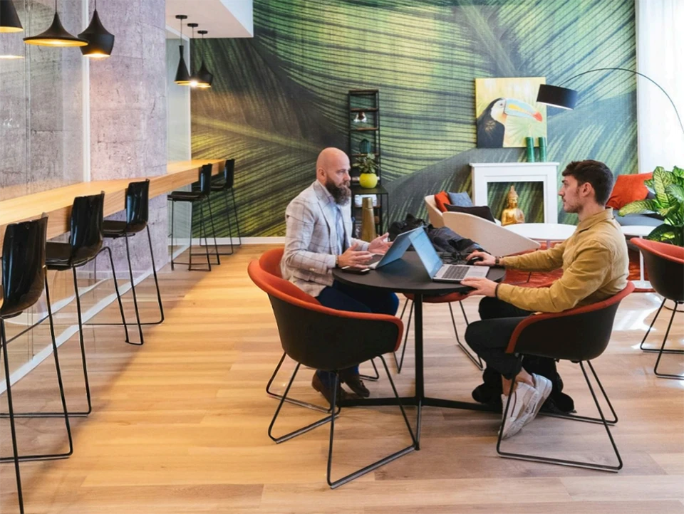 &Eacute;quipe de jeunes professionnels souriants r&eacute;unis autour d'un &eacute;cran d'ordinateur dans un bureau moderne