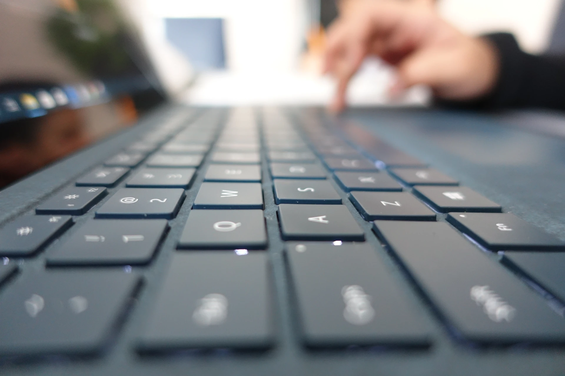 Un homme en chemise à carreaux rouge et noir examine des ordinateurs portables dans un magasin d'électronique moderne