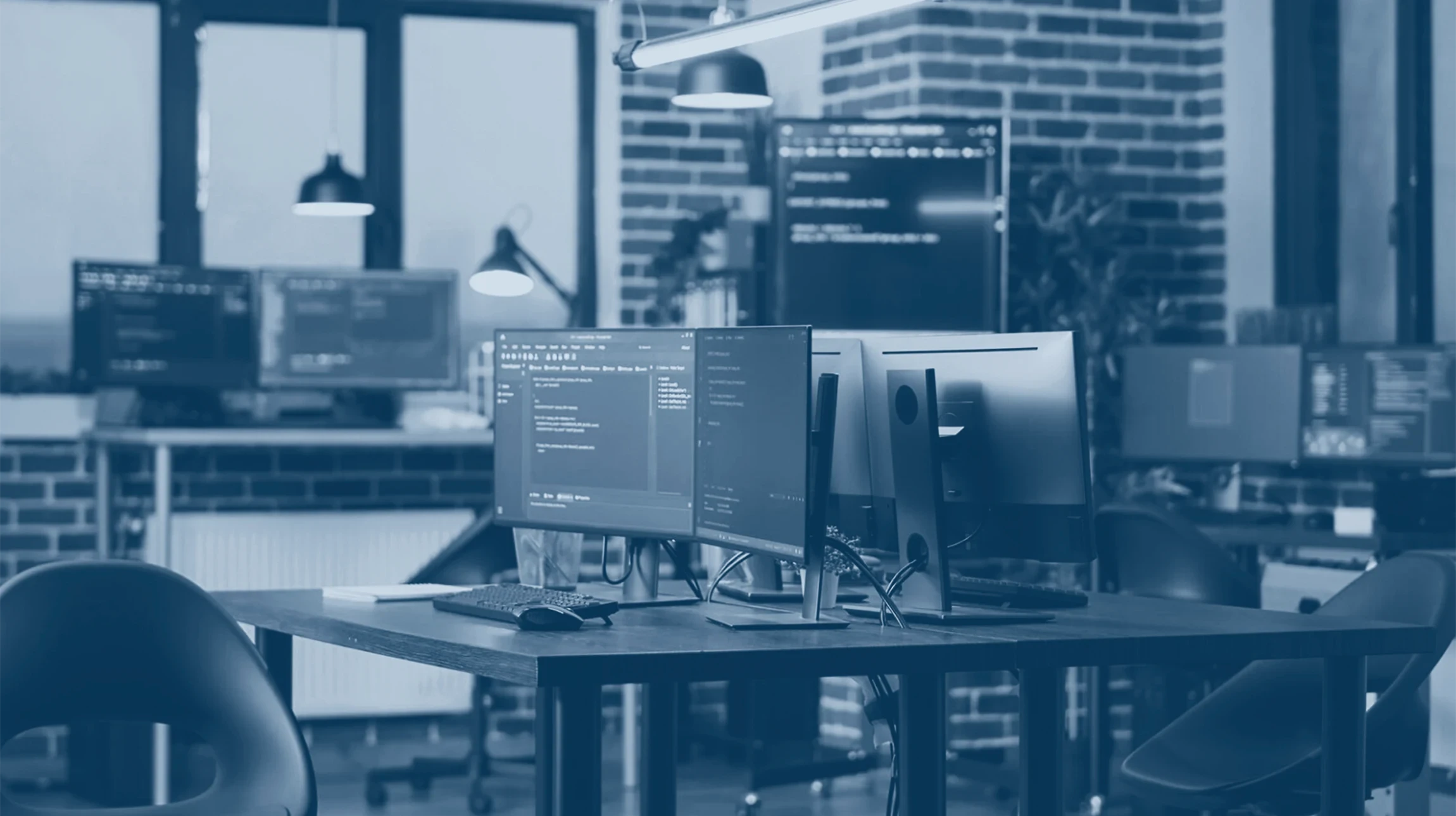 Technicien informatique travaillant dans un datacenter ou salle serveur, manipulant un ordinateur portable devant des équipements réseau