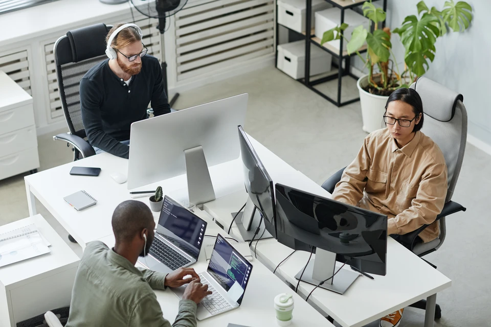 Main tenant un stylo pointe vers un réseau de connexions virtuelles avec icônes de profils professionnels interconnectés